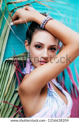 Portrait of beautiful young brunette woman with makeup in swimming suit