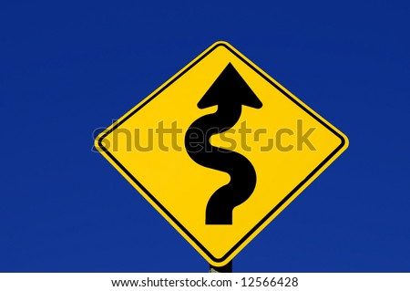 Yellow street sign with curves against blue sky