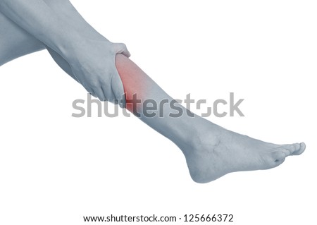 Acute pain in a woman calf. Female holding hand to spot of calf-aches. Concept photo with Color Enhanced blue skin with read spot indicating location of the pain. Isolation on a white background.
