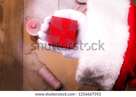 Santa's hand with a gift. Letter and a mug of tea. Wooden background and free space for text. Vintage photo