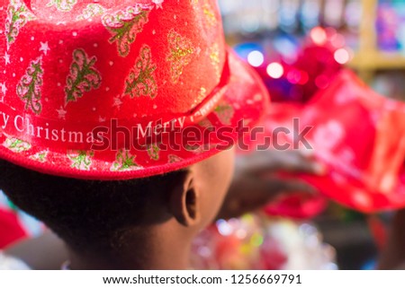 young black boy wearing a christmas hat with blurred background