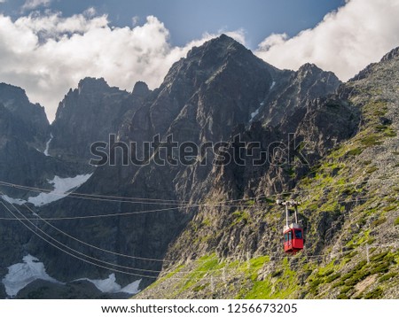 The cable car with rocks in the background captured in Lomnicky stit. High Tatras mountains, Slovakia Royalty-Free Stock Photo #1256673205