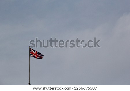 One British flag hoisted on parliament roof against blue sky in BREXIT negotiations by prime minster Theresa May, London, UK. National emblem is Union Jack in Great Britain. Copy space and background 