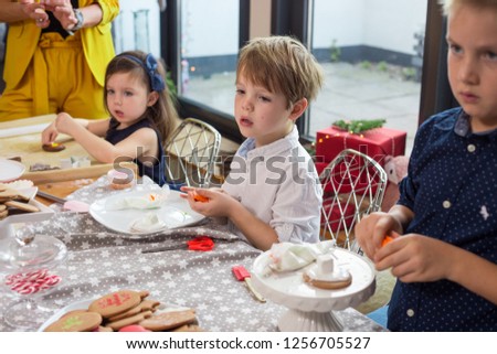 Siblings making Christmas cookies together. Lifestyle, candid image, shallow depth of field.