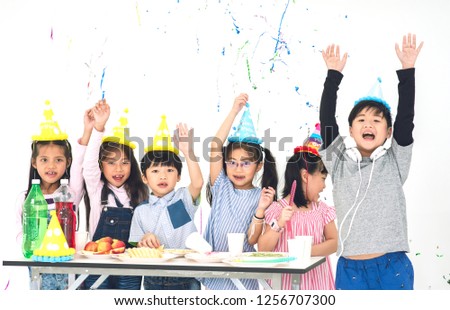 Group of Happy Asian Kids Raise Hands Up and Enjoy Throwing Colorful Confetti with Friends in Celebrate Event Cute Children Having Fun with Friends at School in Christmas New Year Party
