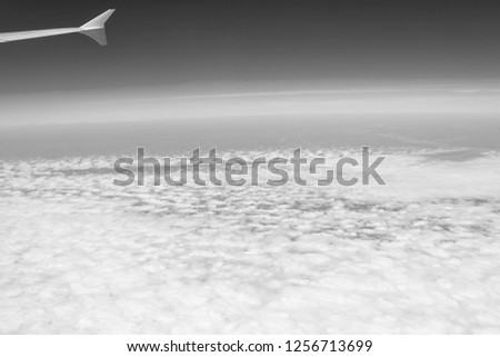 Clouds and sky as seen through window of aircraft.