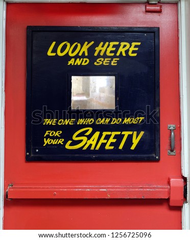 Close up of vintage Safety First industrial door with fun mirror gimmick.