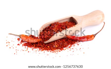 Dry and crushed chili pepper flakes isolated on white background. Red chili peppers in a wooden spoon. Royalty-Free Stock Photo #1256737630