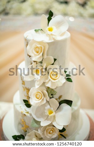 White tiered icing flower cake, with marble texture.