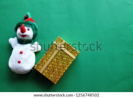top view and flat lay snowman and notebook christmas decorations on green background
