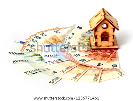 wooden house stands on a pile of euro paper notes