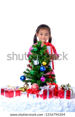 Happy asian child holding Christmas presents with Christmas Tree Decoration and gift boxes. Christmas or happy newyear time isolated on white background with clipping path