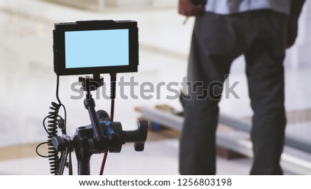 Behind the scenes of film or video production monitor in tv commercial shooting and movie crew team setting up for next shot and waiting for director and agency or clients approve