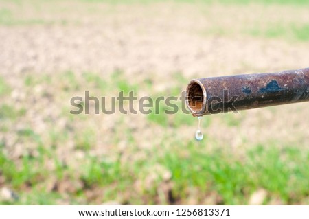 A water drop from the rustic hand pump 