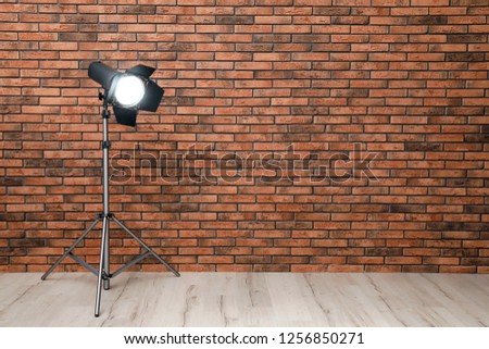 Professional lighting equipment near wall in photo studio. Space for text
