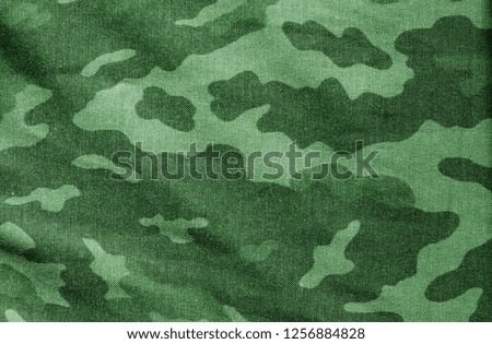 Old camouflage cloth in green tone. Abstract background and texture for design and ideas.