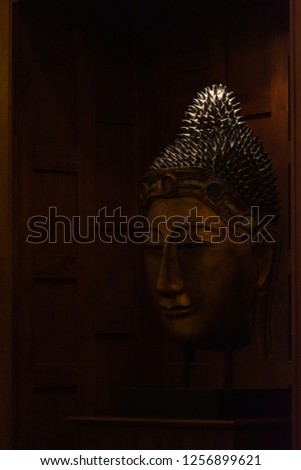 black and white picture of Buddha's head in dark tone.