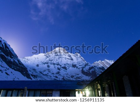 Beautiful view of base camp with snow peak mountain at night. Scenic nightscape of himalaya mountain range. It's landmark and popular for tourist attractions in Nepal. ABC. Annapurna Base Camp. Asia.
