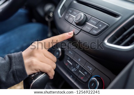 Female finger pointing on emergency stop button closeup