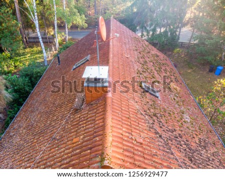Inspection of the red tiled roof of a single-family house, inspection of the condition of the tiles on the roof of a detached house.