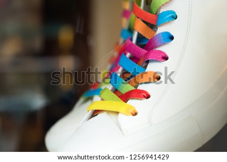 Closeup of a sneaker with colored shoelaces, abstract background