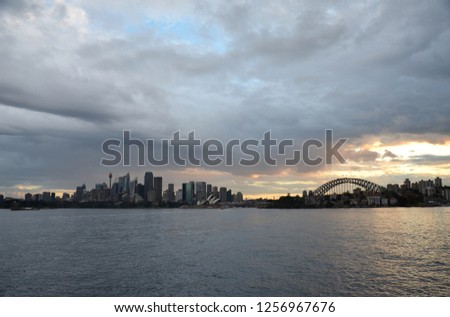Sydney Harbour viewed from Cremorne Point, Australia. The Iconic Landscape of illuminated Sydney city, Opera House and Harbour Bridge at sunset.
