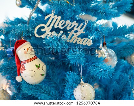 Snowman and the letter Merry Christmas on blue christmas Tree