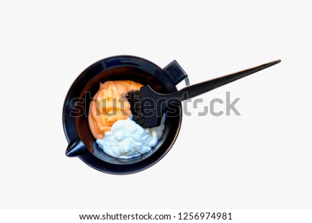 Mixing hair dye in a special plastic bowl. Concept is hair coloring. Isolated on white. Royalty-Free Stock Photo #1256974981