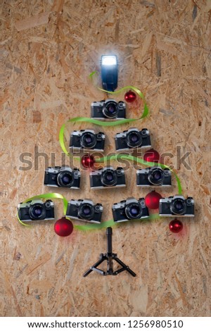 Old retro cameras in Christmas tree shape on wooden background
