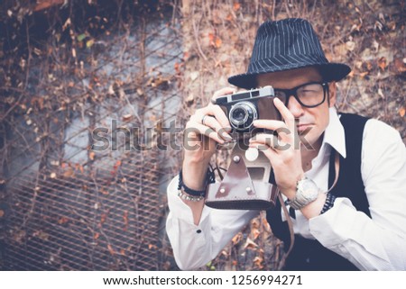 Photographer using retro photo camera and taking pictures outdoors. 