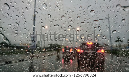 Road view through car window blurry with heavy rain, Concept of driving in rain, bad driving conditions. 