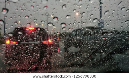 Road view through car window blurry with heavy rain, Concept of driving in rain, bad driving conditions. 