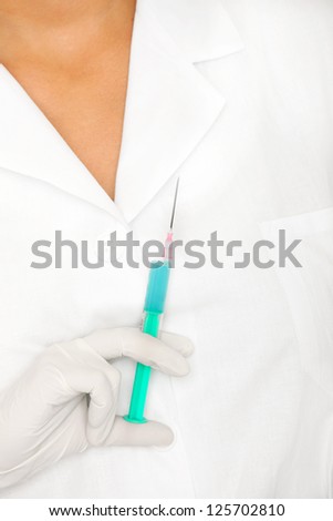 A picture of a doctor holding a disposable syringe over white uniform