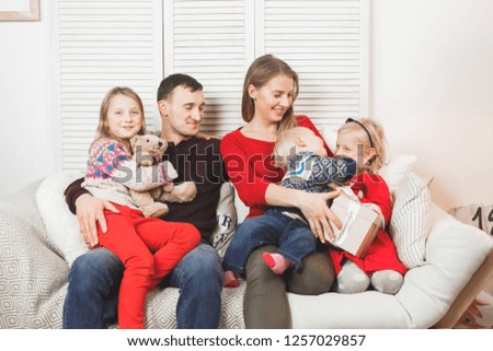 Happy family holding christmas gifts at home