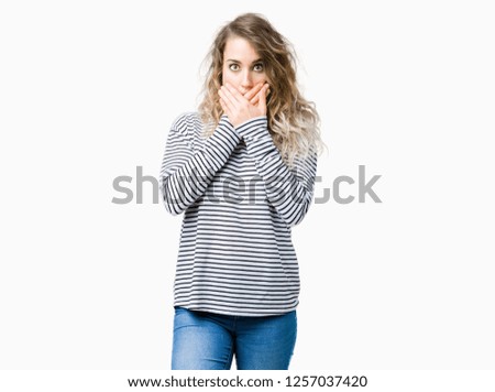 Beautiful young blonde woman wearing stripes sweater over isolated background shocked covering mouth with hands for mistake. Secret concept.