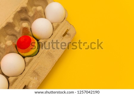 LGBT concept. Chicken egg painted in stripes among other white eggs