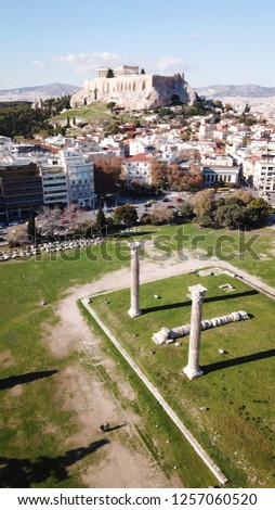 Aerial drone photo of iconic pillars of Temple of Olympian Zeus and world famous Acropolis hill with masterpiece Parthenon on top at the background, Athens historic center, Attica, Greece