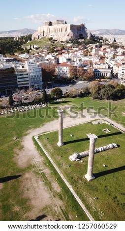 Aerial drone photo of iconic pillars of Temple of Olympian Zeus and world famous Acropolis hill with masterpiece Parthenon on top at the background, Athens historic center, Attica, Greece