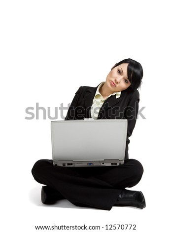 A businesswoman sitting on the floor working on her laptop