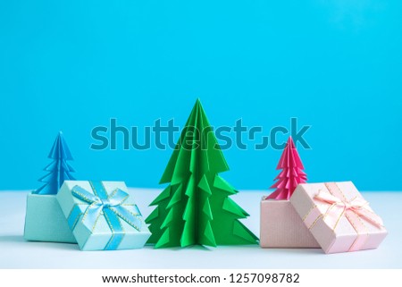 Gift boxes with origami christmas trees winter holiday minimal creative concept. Space for copy.