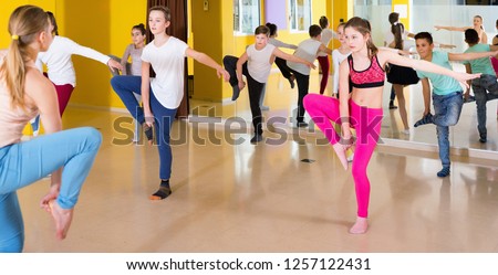 Happy cheerful positive smiling teenagers dancers practicing dance routine with female choreographer in modern studio
