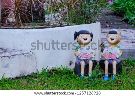Statue of children holding a sign in the lawn.