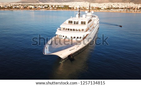Aerial drone photo of luxury yacht docked in deep blue sea outside mediterranean port