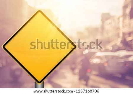 Empty yellow traffic sign on blur traffic road with colorful bokeh light abstract background. Copy space of transportation and travel concept. Retro tone filter effect color style.