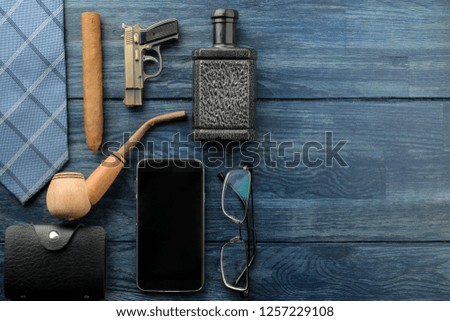 Men's Accessories.men's style. Smartphone, perfume, smoking pipe glasses, cigar and business card holder. on blue wooden background. lay. with space for text