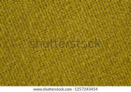 Texture of thick, strong mustard color fabric shot close-up.