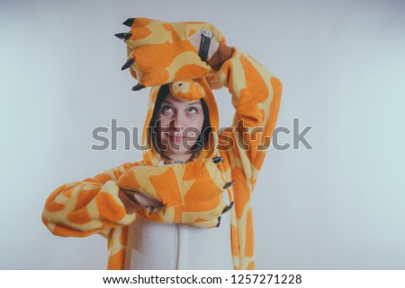pajamas in the form of a giraffe. emotional portrait of a girls on an orange background. crazy and funny girl in a suit. animator for children's parties
