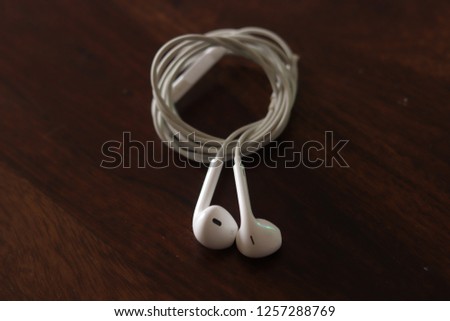 White earphones on brown table
