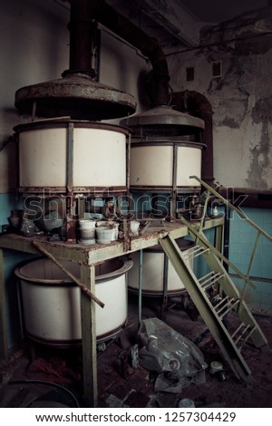 Old rusty small vats in abandoned chemical factory.
