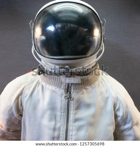 White astronaut or spaceman suit and helmet on grey background, close up